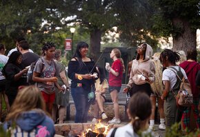 Students gather around a fire pit to socialize during Welcome Weekend