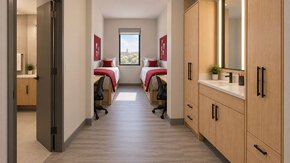 Dorm room with parallel twin beds and en-suite dressing area.