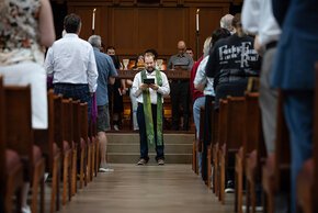 Pastor Vern, framed by congregation, reads during chapel service