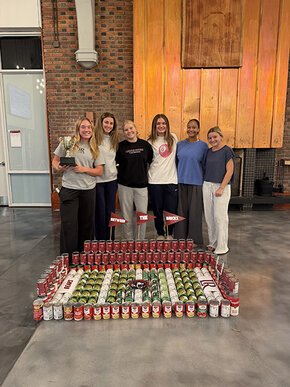 Womens lacrosse players pose behind finished can model of Moretz Stadium