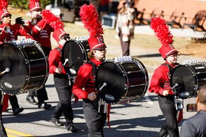 Spirit of LR Marching Band bass drums in uniform in 2025 homecoming parade