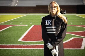 Lindsey Gustafson in uniform with the LR logo and football field behind