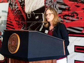 Athletic Director Kim Pate speaks at a podium unveiling the center