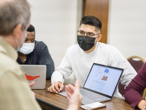 Moises Vazquez interacts with a professor inside a classroom.