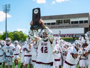 All-American and all-time scoring record holder Eric Dickinson ’21 holds up the South Atlantic Conference championship trophy. 