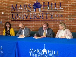 Administrators from Lenoir-Rhyne University and Mars Hill University sign partnership agreement at table