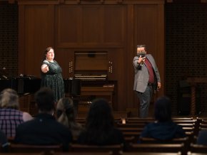 Two people stand on stage