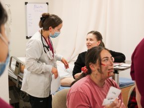 Student nurses work with classmates as part of a disaster simulation