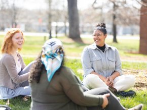 D.M. Spratley, right, sits with two students outside during a class