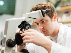 Chase White works with a microscope in a science lab