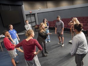 Group of theatre students on stage in a circle