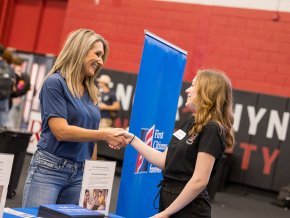 A student shakes hands with a representative from First Citizens at Success Fest 2023