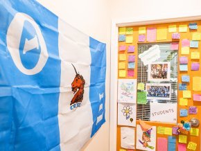 The door to Toni Oakes' office covered with post-it notes from students, Theta Xi flag to the left