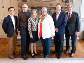 Five alumni award winners and President Whitt stand in front of a stone wall.