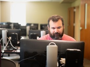 Mike Gerbitz works behind a computer screen in a campus lab