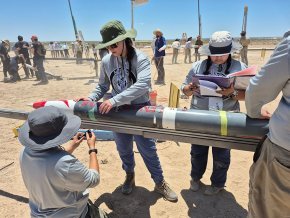 Rocket team members secure their 2025 rocket to the launch rail in the Texas desert