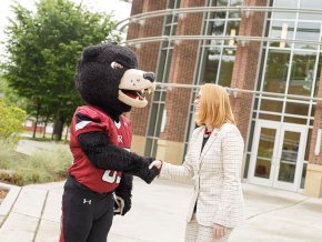 Summer McGee and Joe Bear shake hands in front of George Hall