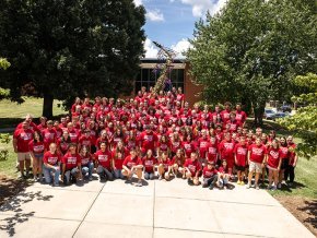 All members of Youth Summer Music Camp in a group in font of Mauney Music Building and the Super Sax statue