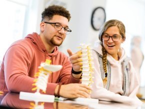 Two students discuss the anatomy lab assignment during class