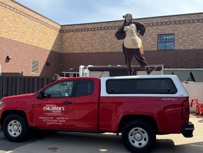 Kaylyn Hall stands on top of the MCT Red Truck in her Baloo the Bear costume.