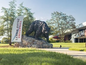 The Charge statue next to a Lenoir Rhyne Banner and Cromer Center in the background