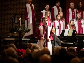 Student sings a solo with the choir in the background during a Lenoir-Rhyne Christmas 