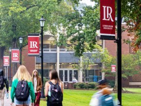 Students walk on campus in front of Rudisill Library