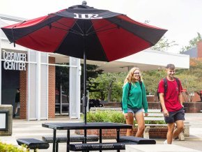 Two students walking by Cromer Center on way to class