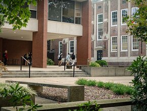 Students walking in front of Lineberger Administration Building into Rhyne Building