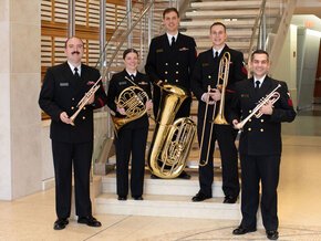U.S. Naval Band Wind Ensemble poses with their instruments