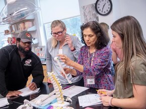 Professor talks with students during a science lab