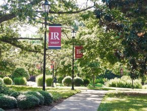 LR Banners along a sidewalk with flowers on a sunny summer day