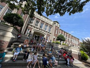 Kids in College students working and socializing on the steps of Rhyne Building