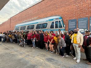 Lenoir-Rhyne and Southeast Louisiana choirs pose in front of a Freedom Rides bus mural