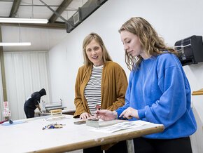 Claire Pope works with a student in the LR art studios