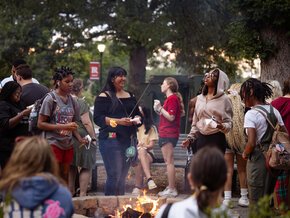 Students gather around a fire pit to socialize during Welcome Weekend