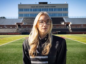 Lindsey Gustafson in uniform aligned with Moretz Stadium box in background