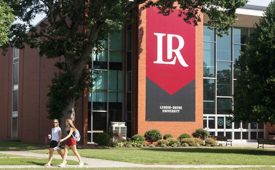 Students walking on in front of P.E. Monroe Auditorium on LR campus