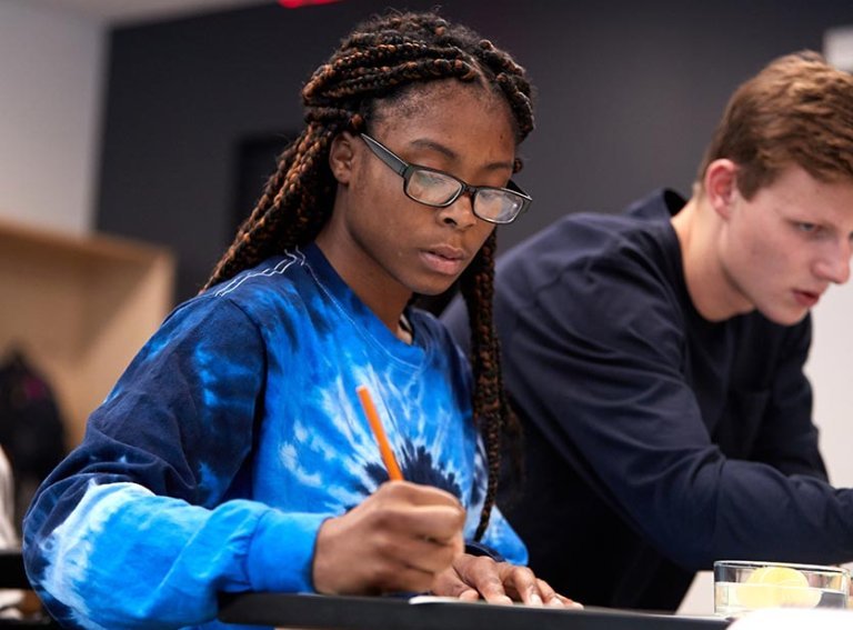 Student takes notes during class lecture