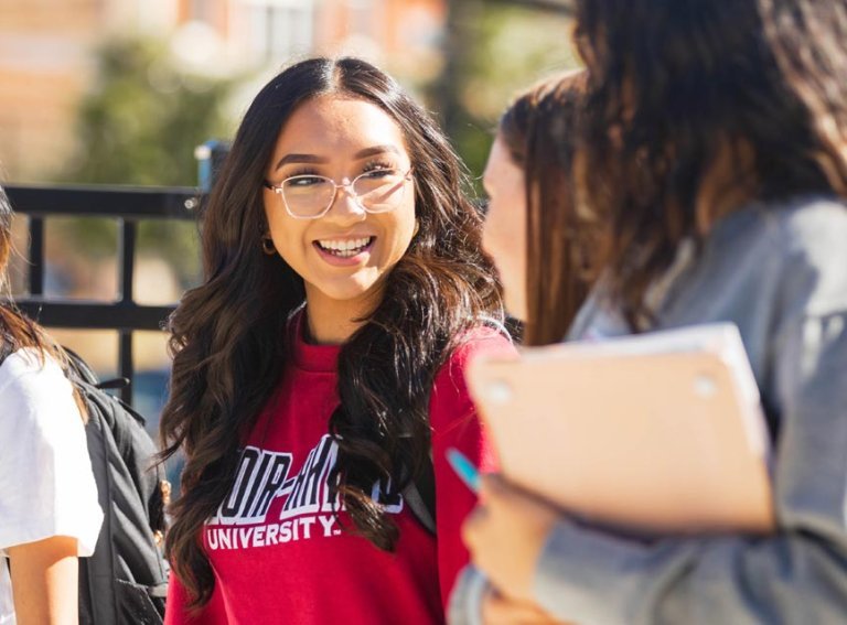 Four LR students walking and talking on City Walk sidewalk
