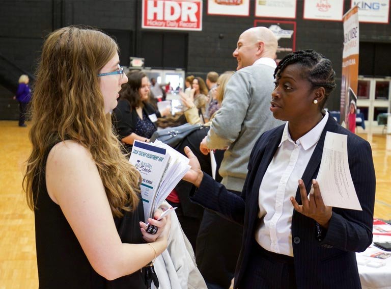 Student talks to employer at career fair on campus