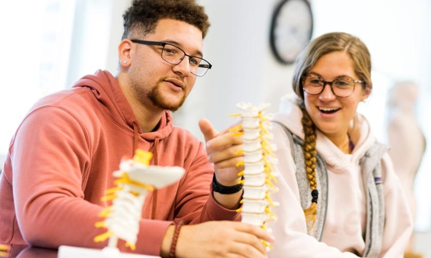 Two students discuss the anatomy lab assignment during class