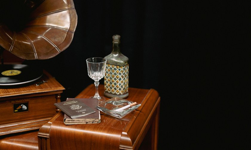 Stage props for Cabaret--gramophone, decanter, glass, passport, ashtray on a table