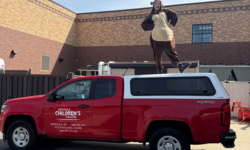 Kaylyn Hall stands on top of the MCT Red Truck in her Baloo the Bear costume.