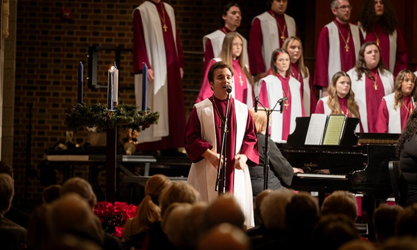 Student sings a solo with the choir in the background during a Lenoir-Rhyne Christmas 