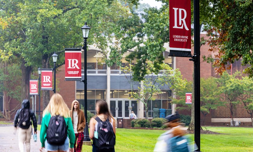 Students walk on campus in front of Rudisill Library