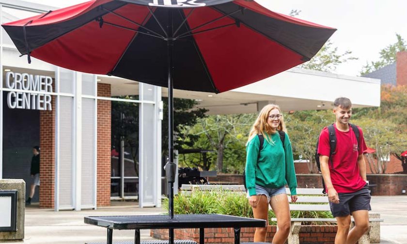Two students walking by Cromer Center on way to class