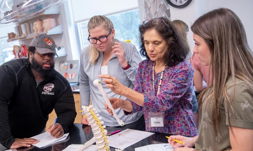Professor talks with students during a science lab