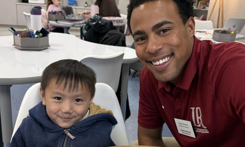 A LR education major poses for photo in literacy center with student
