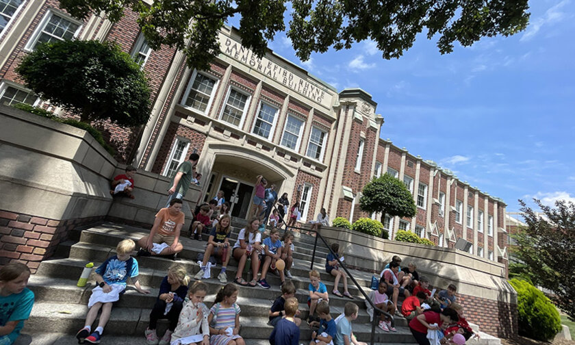 Kids in College students working and socializing on the steps of Rhyne Building